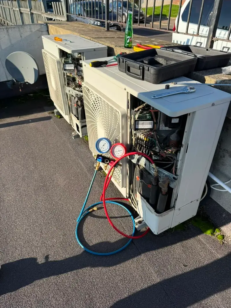 Refrigerant gauges connected to an opened air conditioning condenser during a service