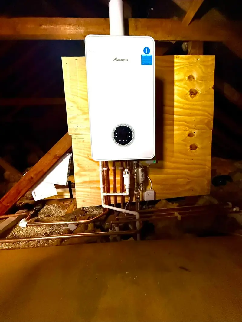 Worcester boiler mounted on a board in a loft with new copper pipework below