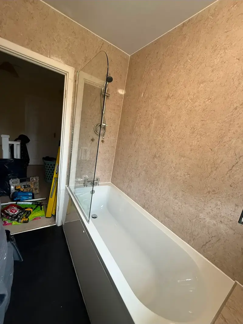 New bath and shower screen fitted, walls part finished