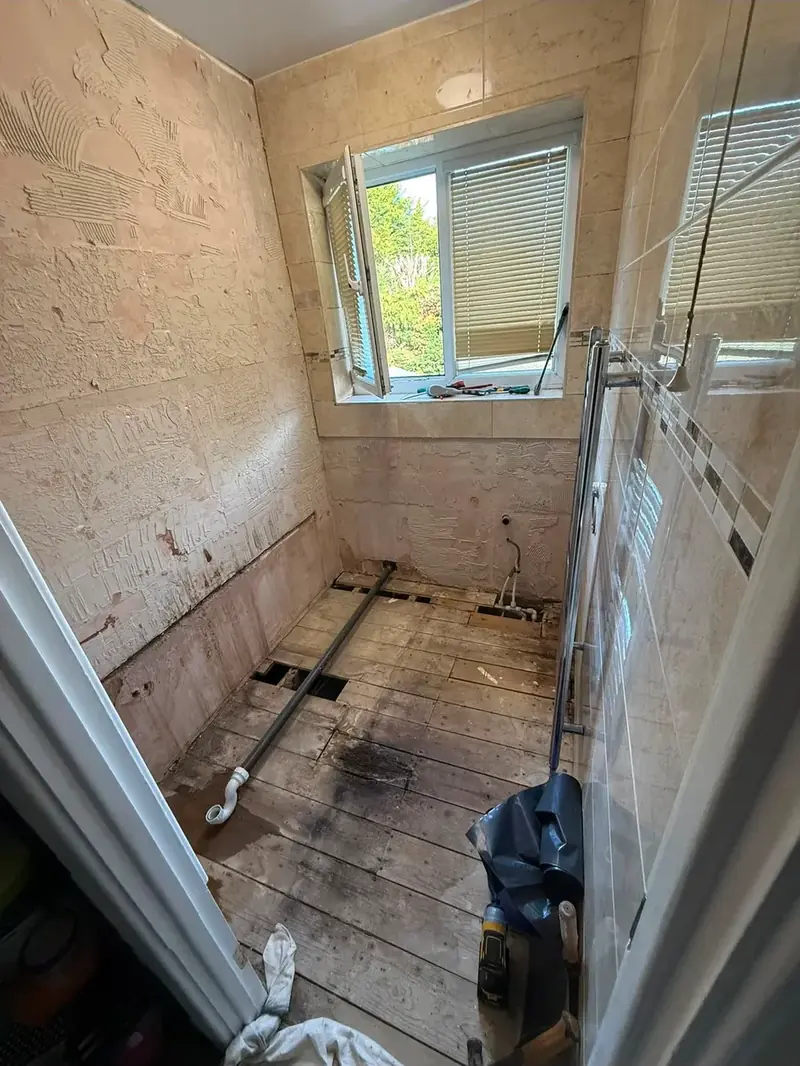 Bathroom mid-installation with the floor up and the enclosure already set