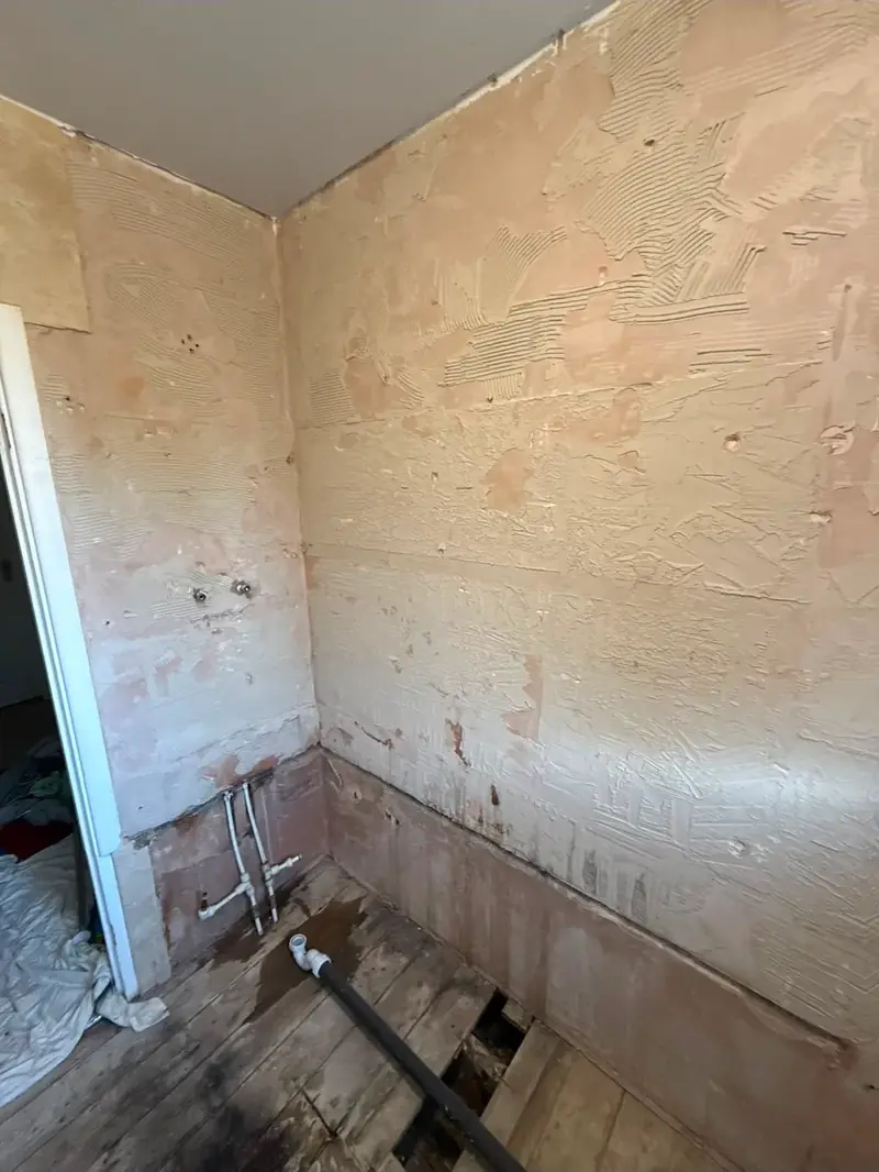 Bathroom stripped back to bare walls before the new suite goes in