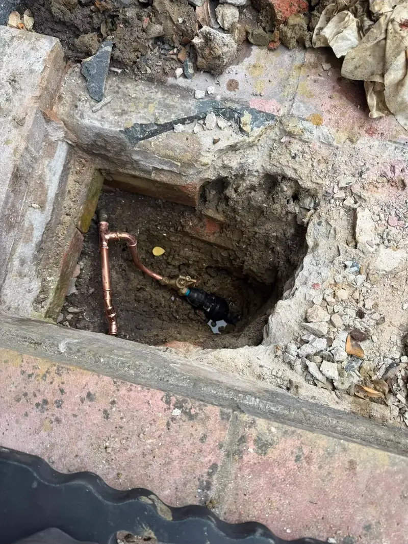 New copper pipe run in a channel cut through a solid floor
