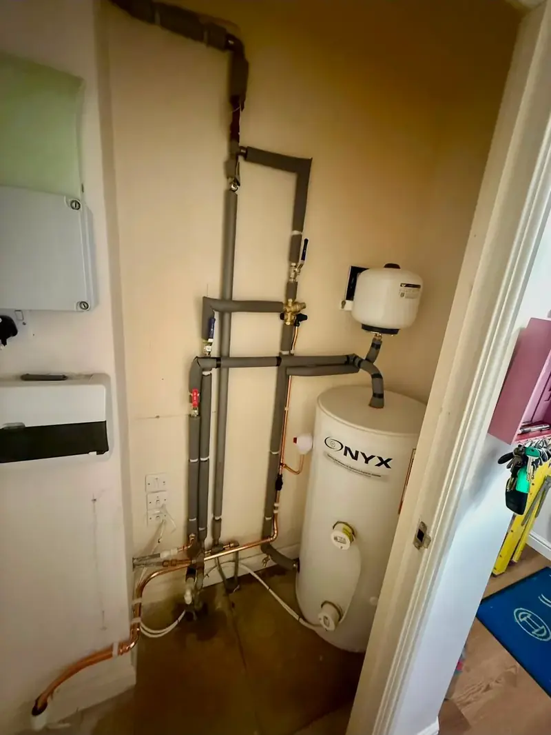 Unvented hot water cylinder with copper pipework in an airing cupboard