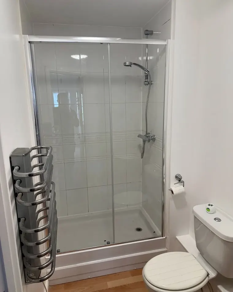 Finished shower enclosure with a heated towel rail